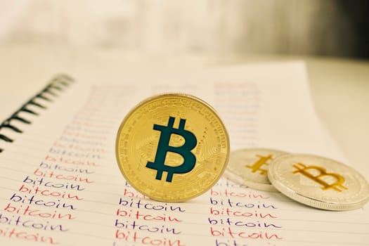 Digital currency physical gold and silver bitcoin coins in notebook.