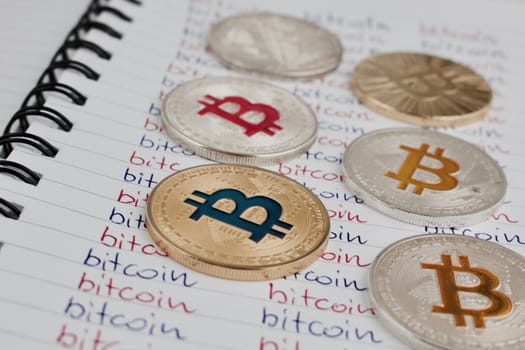 Cryptocurrency physical silver and gold bitcoin coin in notebook.