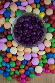 Tasty purple jelly candies in jar near colorfull candies around.