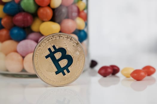 Digital currency physical gold bitcoin coin near colorful sweet composition.