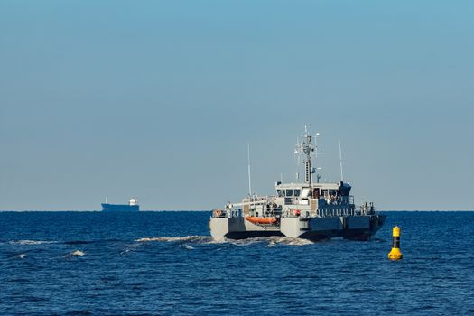 Small grey military ship moving from Baltic sea