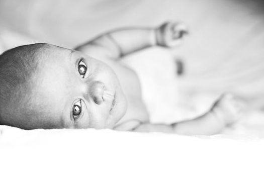 Beautiful baby girl on white blanket. Studio shot