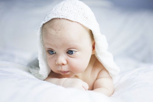 Beautiful baby girl on white blanket. Studio shot