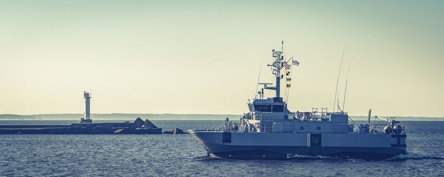 Small grey military ship moving from Baltic sea