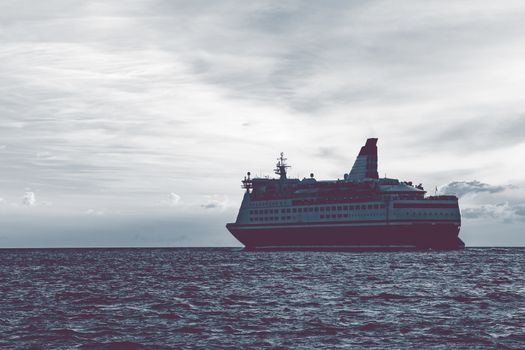 Cruise liner in open sea. Passenger ferry sailing at hot sunset