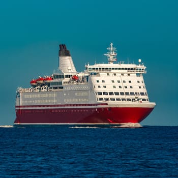 Red cruise liner. Large passenger ferry underway