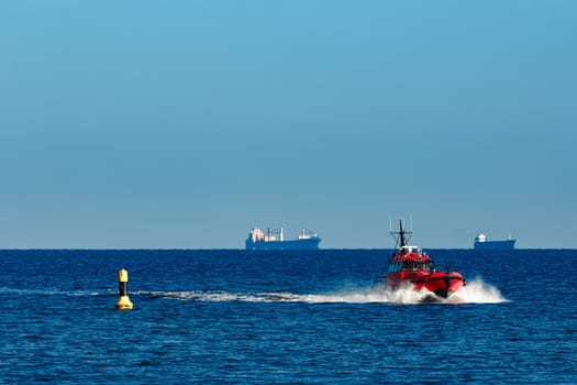 Red pilot ship moving from the Baltic sea