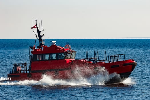 Red pilot ship moving from the Baltic sea