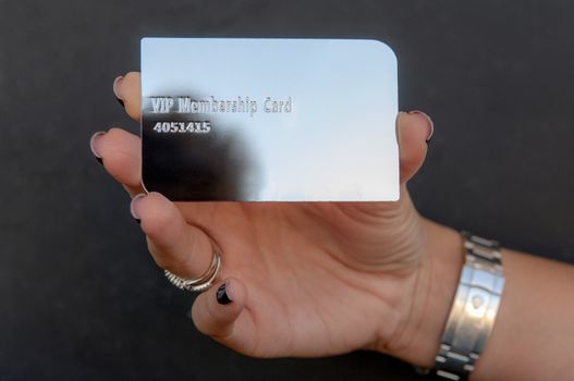 woman is holding a silver vip card