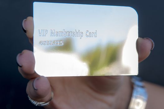 woman is holding a silver vip card