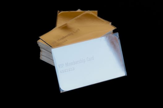 stack of golden vip cards on black leather surface