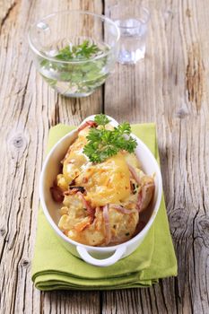 Dish of potatoes with ham and cream baked with cheese