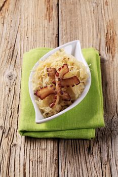 Bowl of sauerkraut garnished with slices of pork fat