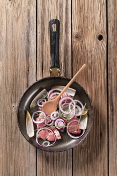 Pieces of meat and onion on frying pan