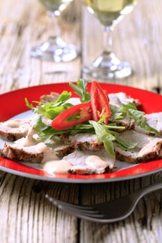 Slices of roast pork tenderloin garnished with salad greens