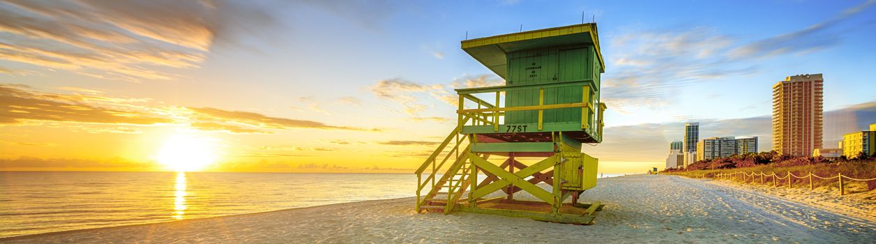 Miami South Beach sunrise with lifeguard tower and coastline with colorful cloud and blue sky. 