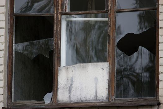 Broken windows in an old abandoned brick building