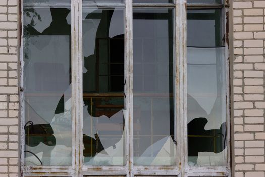 Broken windows in an old abandoned brick building