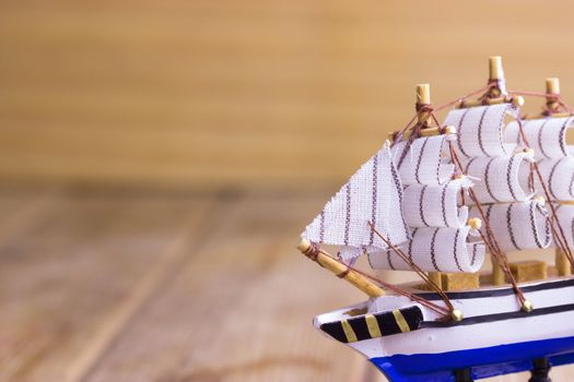 Toy sailboat on a wooden background with copy space