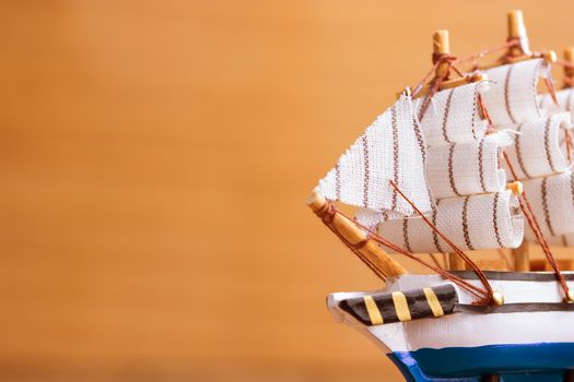 Toy sailboat on a wooden background with copy space