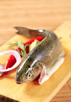Fresh trout and other ingredients on cutting board