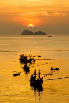 Orange sky with sunset over sea shore and silhouette fishing boat,Hat Pha Daeng Chumphon Thailand.