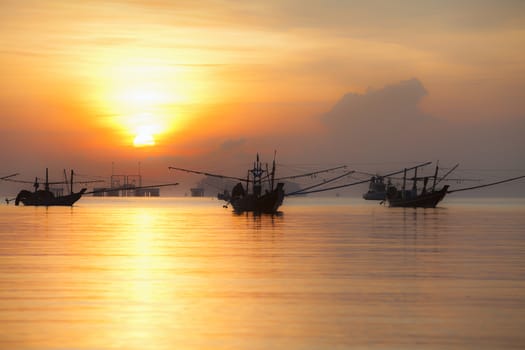 Orange sky with sunset over sea shore and silhouette fishing boat,Hat Pha Daeng Chumphon Thailand.