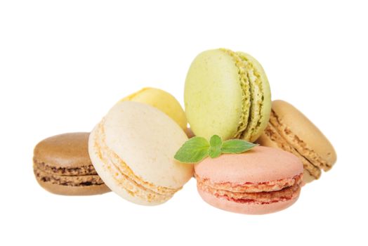 Several multicolored macaroons pastel colors with green mint leaves isolated on white background