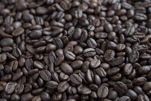 Large coffee background: roasted coffee beans close-up in perspective