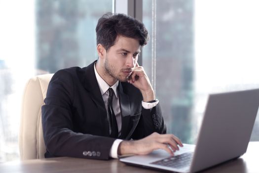 Busy businessman in office working on his laptop.