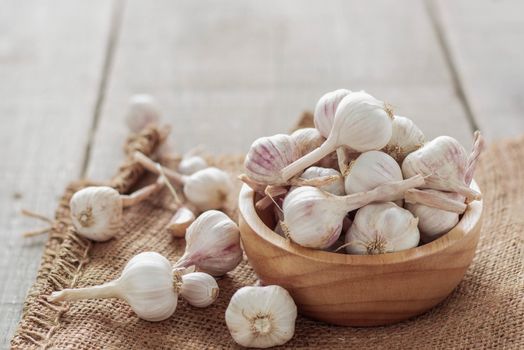 Garlic in a bowl on wooden floor.