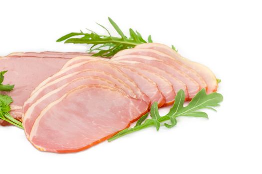 Sliced boiled smoked pork loin and ham with arugula and parsley leaves closeup on a light background
