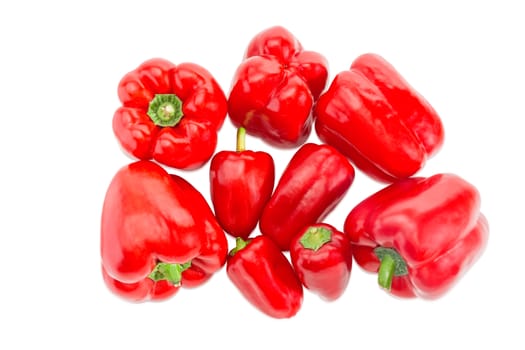 Several fresh red bell peppers different sizes on a light background
