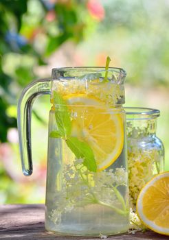 Elder lemonade with lemon on old table wood