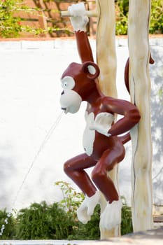 Plastic monkey used as a water jet in a park in Crete