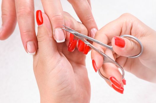 Nail salon, hands beauty treatment, cuticles cutting with scissors