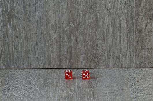 Throwing red dice on a grey background in the casino.