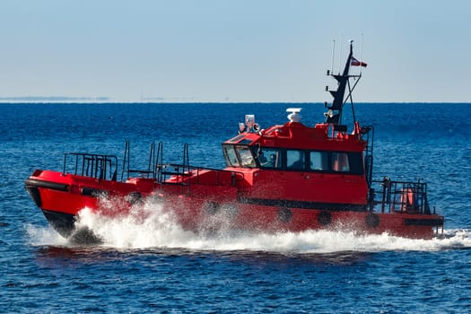 Red pilot ship moving from the Baltic sea