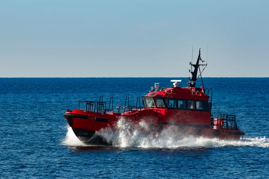 Red pilot ship moving from the Baltic sea