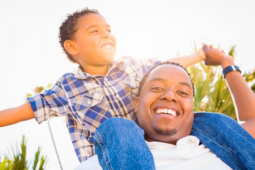 Mixed Race Son and African American Father Playing Piggyback Outdoors Together.