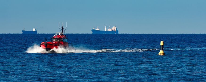 Red pilot ship moving from the Baltic sea