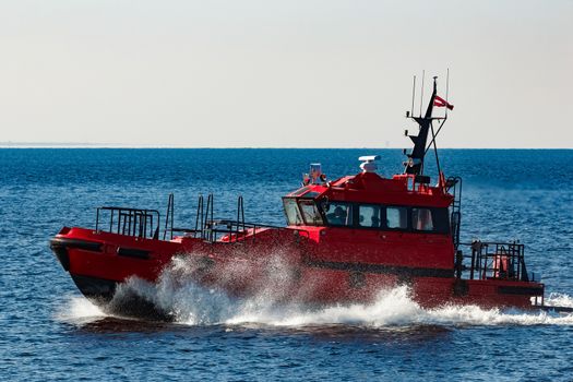 Red pilot ship moving from the Baltic sea