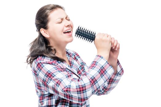 Portrait of a singer in pajamas with a comb for hair on a white background