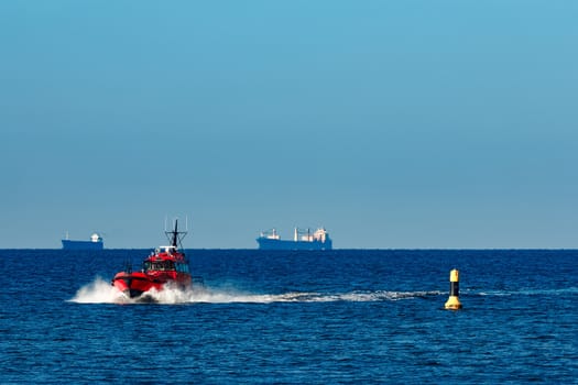 Red pilot ship moving from the Baltic sea