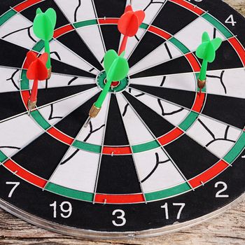 The darts on a wooden background closeup