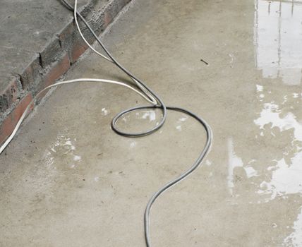 COLOR PHOTO OF WIRE ON WET CONCRETE GROUND