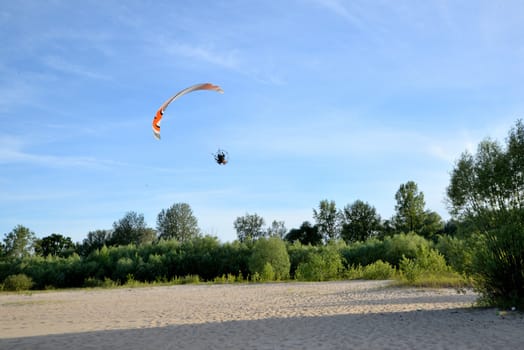 A jetliner flying over the sandy banks of a river on a sunny summer day