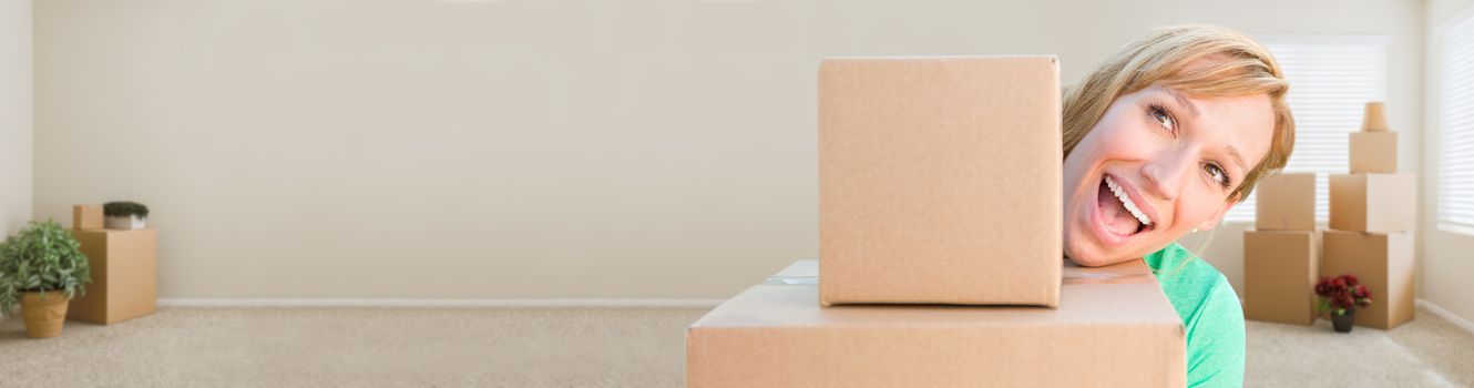 Banner of Happy Young Adult Woman Holding Moving Boxes In Empty Room In A New House.