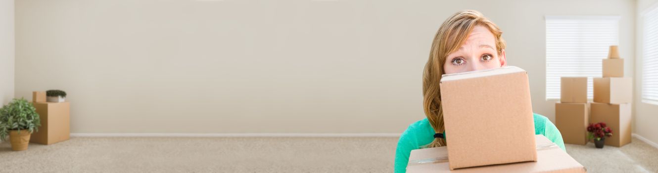 Banner of Happy Young Adult Woman Holding Moving Boxes In Empty Room In A New House.