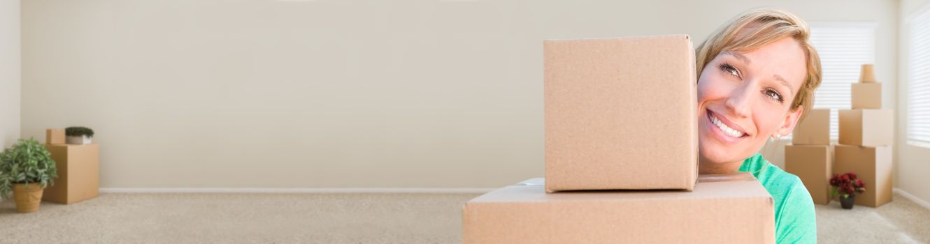 Banner of Happy Young Adult Woman Holding Moving Boxes In Empty Room In A New House.